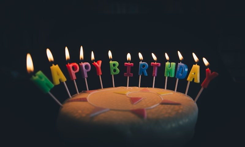Birthday cake topped with lit letter-shaped candles