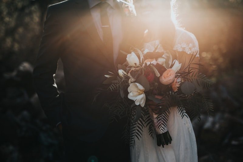 Couple holding a bouquet outdoors at sunset