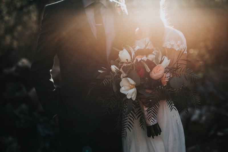 Couple holding a bouquet outdoors at sunset